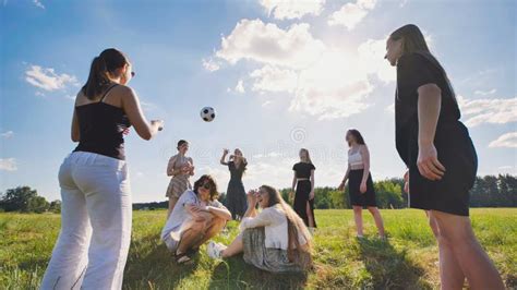 Friends Toss A Ball To Each Other In A Meadow On A Summer Day Stock Photo Image Of Mature