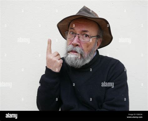 Portrait Of Mature Man Making Face Against White Wall Stock Photo Alamy