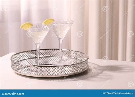 Tray With Martini Glasses Of Fresh Cocktail And Lemon Slices On White