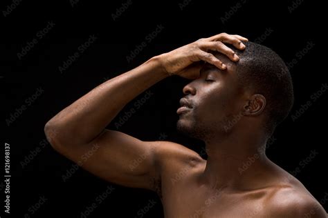 Portrait Of Naked Passionate Afro American Man Touching His Head While Posing Over Black