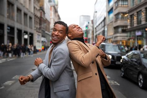 Casal gay sendo carinhoso e agindo como um pateta em uma rua da cidade Foto Grátis