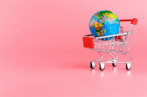 Premium Photo Small Globe In A Shopping Cart On A Pink Background