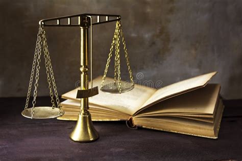 Винтажные латунные весы правосудия и старая книга на коричневом Woode ...