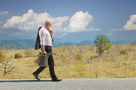 Full Length Profile Shot Mature Man Walking Petrol Canister Stock