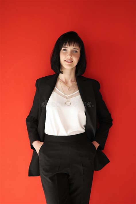 Hermosa Mujer Empresaria De Brunette Ceo Con Traje Negro Aislado En El Fondo Rojo Parado