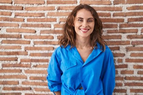 Free Photo Beautiful Brunette Woman Standing Over Bricks Wall With A Happy And Cool Smile On
