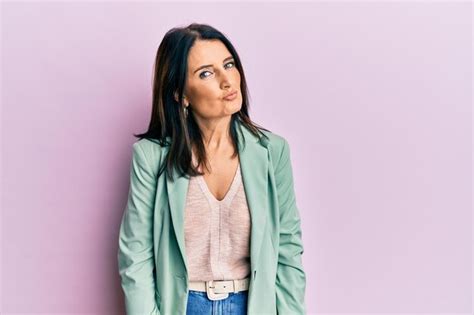 Free Photo Middle Age Brunette Woman Wearing Casual Clothes Looking At The Camera Blowing A