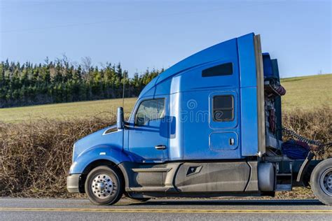 Profile Of Blue Big Rig Bonnet Semi Truck Tractor Running On The Road