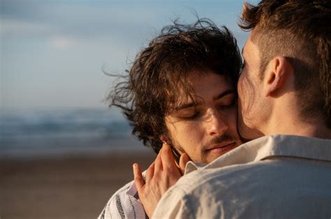 Casal gay de vista lateral na praia Foto Grátis
