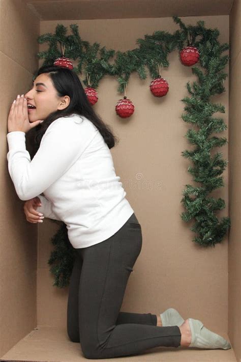 25 Year Old Latina Woman Inside A Cardboard Box Decorated As A Gift To Celebrate Christmas And