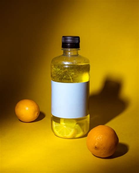 Free Photo | Side view of detox drink with lemon in a bottle on dark yellow