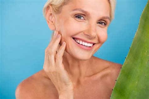 Photo Of Positive Cheerful Elderly Lady Naked Shoulders Arm Touch Cheekbone Applying Aloe Balm