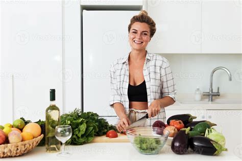 Young cheerful woman cooking healthy vegetarian dish at home 14407681 ...