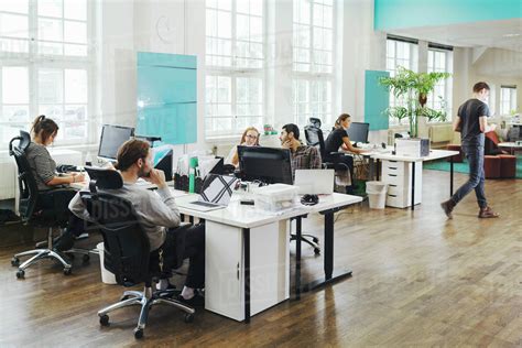 Business People Working At Desks In Creative Office Stock Photo