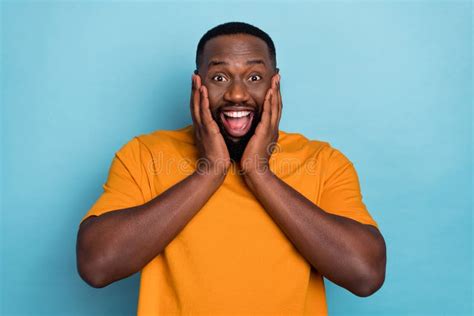 Photo Of Funky Shocked Guy Dressed Orange T Shirt Smiling Arms Cheeks