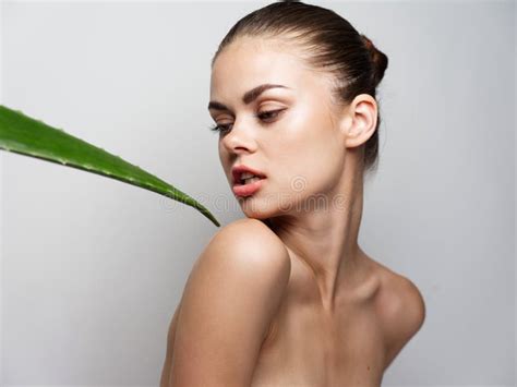 Woman Looks Back To The Side Naked Shoulders And Aloe Leaf Clean Skin Cosmetology Stock Photo