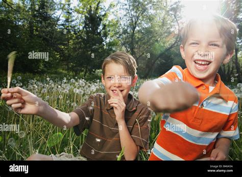 Two Blonde Brothers Playing With Dandelions And Having Fun Stock Photo Alamy