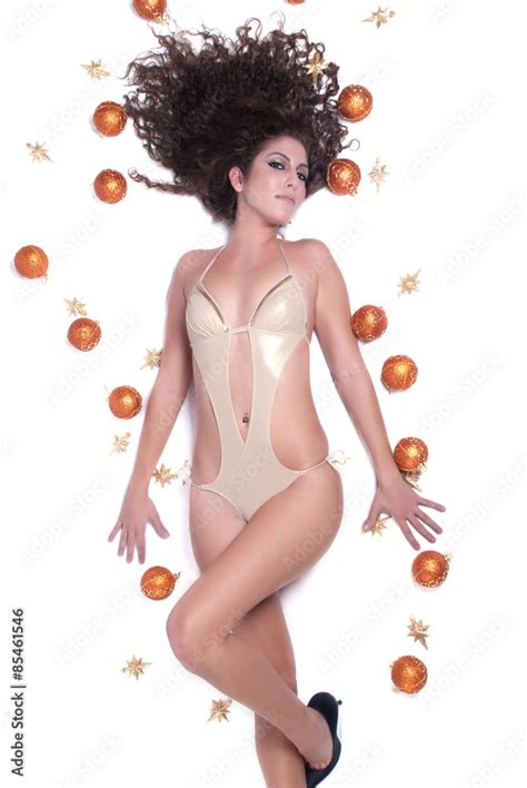Attractive Sexy Woman With Shine Gold Bikini Lying On Her Back There Are Christmas Balls Around