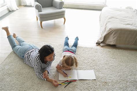 Mother drawing with little girl daughter, lying on floor at home. Art hobby, children's ...