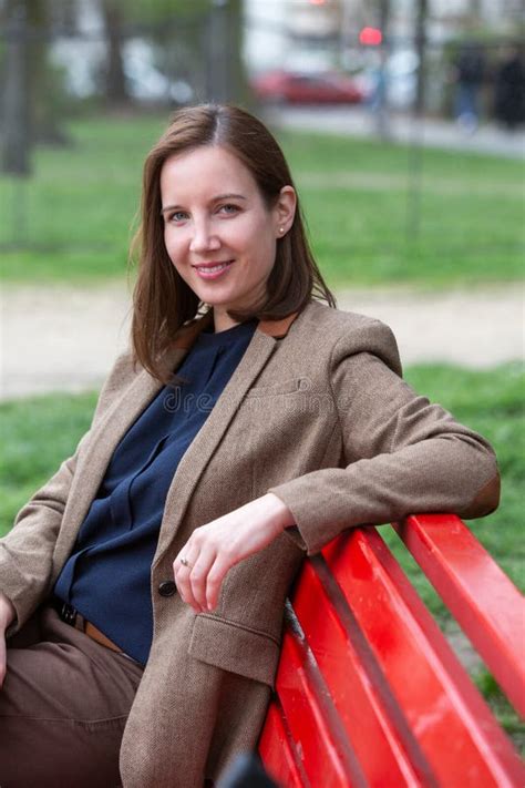 Portrait Of Brunette Woman In A Suit Sitting Outside On Bench Stock Image Image Of Cheerful
