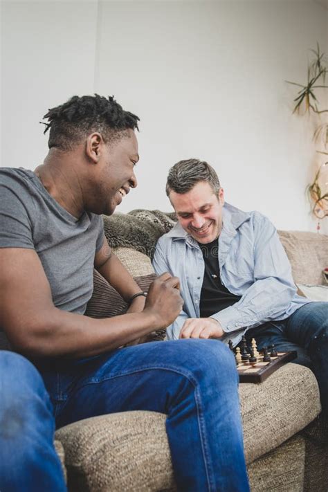 A Gay Couple Enjoying Time Indoors At Home Playing Chess Stock Photo Image Of Lgbtq Love
