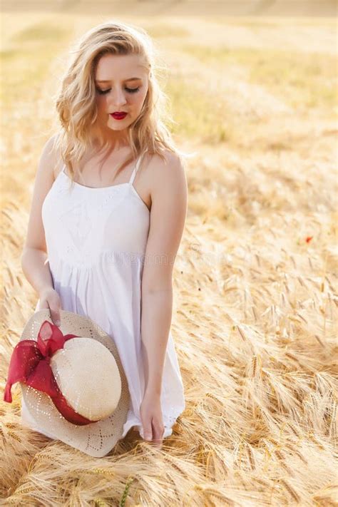 Belle Jeune Fille Blonde Seule Dans La Robe Blanche Avec Le Chapeau De Paille Image Stock