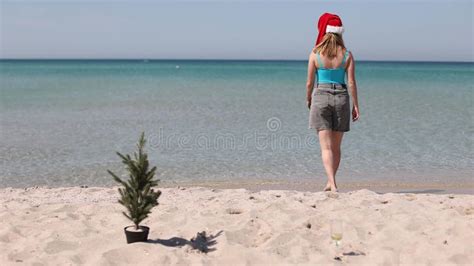 Woman In A Bikini In A Santa Claus Hat Is Relaxing On The Island Of Paradise Beach Stock