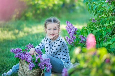 Petite Fille Blonde Mignonne De Sourire D Enfant 4 9 Ans Avec Un Bouquet De Lilas Dans Les Mains