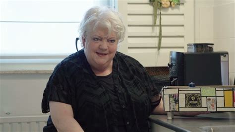 An Older Woman Sitting At A Kitchen Counter