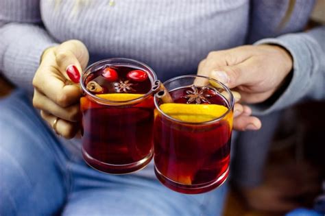 Premium Photo Hot Mulled Wine In Male And Female Hands Spices