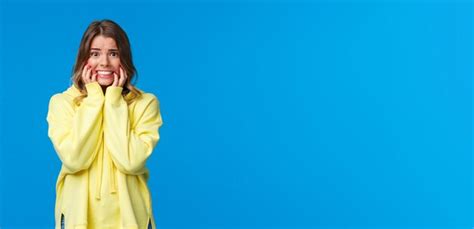 Gêné Et Effrayé Jeune Femme De Race Blanche Blonde Timide En Sweat à Capuche Jaune Paniquant