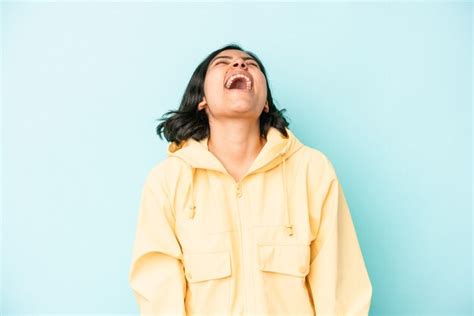 Jovem mulher latina isolada sobre fundo azul relaxada e feliz rindo pescoço esticado mostrando