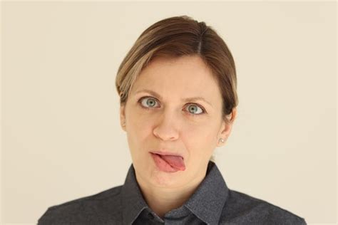 Premium Photo Blonde Woman Sticks Tongue Out Grimacing And Looking At Camera Female Person