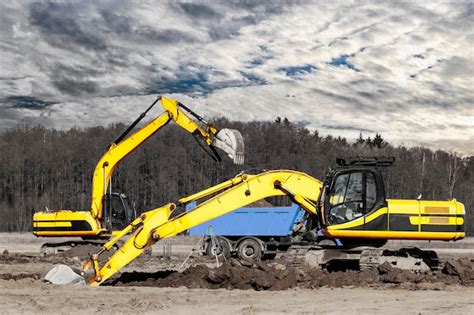 Premium Photo A Powerful Crawler Excavator Loads The Earth Into A