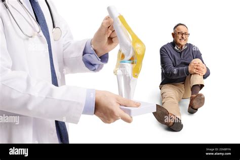 Docteur tenant un modèle d os de genou et homme mature avec douleur de jambe assis derrière