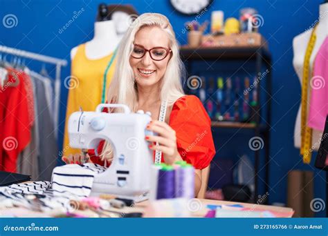 Young Blonde Woman Tailor Smiling Confident Using Sewing Machine At