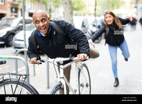 Thief Steals Bike From A Woman On Street Stock Photo Alamy