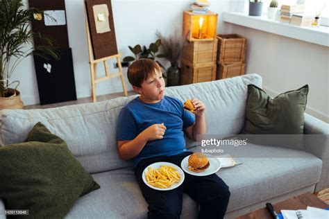 Overweight Teenage Boy Eating Junk Food Hamburger High-Res Stock Photo ...