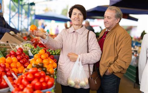 Joyful Mature Male And Female Picking Fresh Oranges At Local Market Stock Image Image Of
