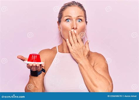 Femme Blonde Caucasienne D Ge Moyen Tenant La Gel E De Fraise Douce Couvrant La Bouche Avec La