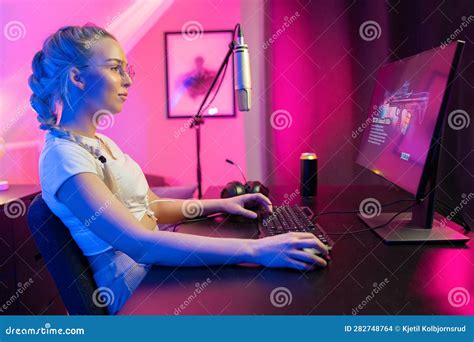 Focused Beautiful Blonde Gamer Girl Playing Online Video Game On Her Personal Computer Stock