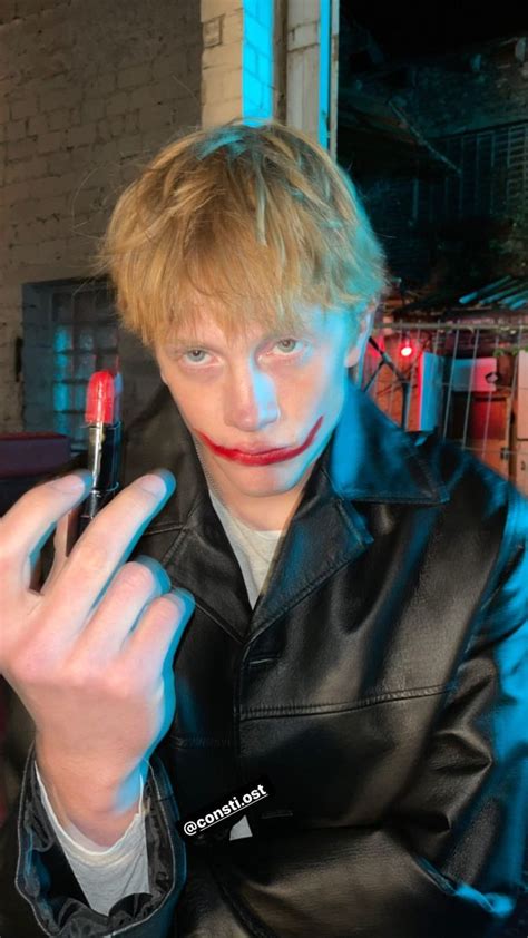 A Man With Red Lipstick On His Face Holding A Pen