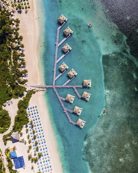 Aerial View Of Turquoise Waters And Overwater Bungalows At Coco Cay