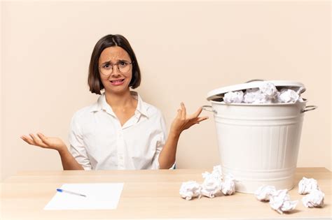 Joven mujer latina que parece perpleja confundida y estresada preguntándose entre diferentes