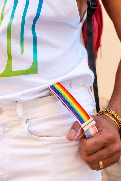 Suspensórios arco íris a mão de um homem de etnia negra gay na bandeira lgbt da festa do