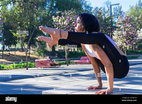 Cute Brunette Yoga Instructor Concentrating And Doing Tittibhasana Standing On Her Hands In The