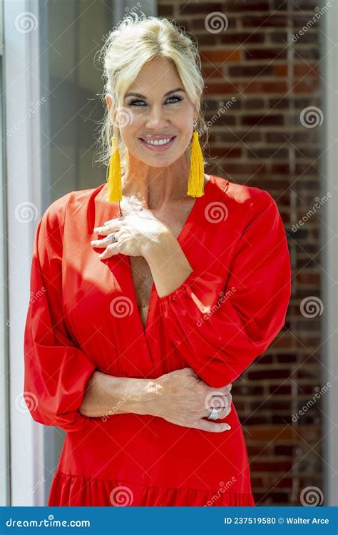 Une Belle Mannequin Blonde Pose Dans Un Environnement Familial Avec Une Robe D été Rouge Photo