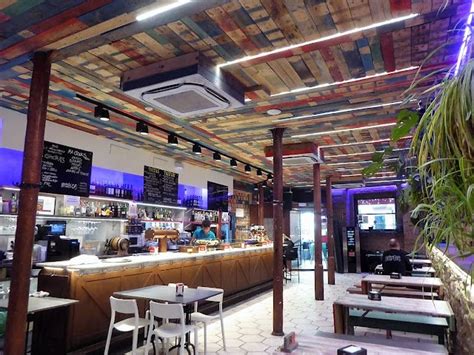 The Inside Of A Restaurant With Tables And Chairs In Front Of An Open