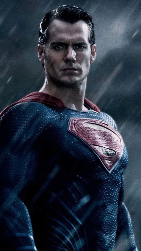 A Man In A Superman Suit Standing In The Rain With His Hands On His Hips