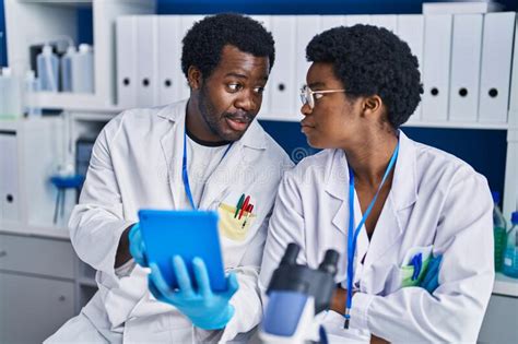 African American Man And Woman Scientists Using Touchpad Working At